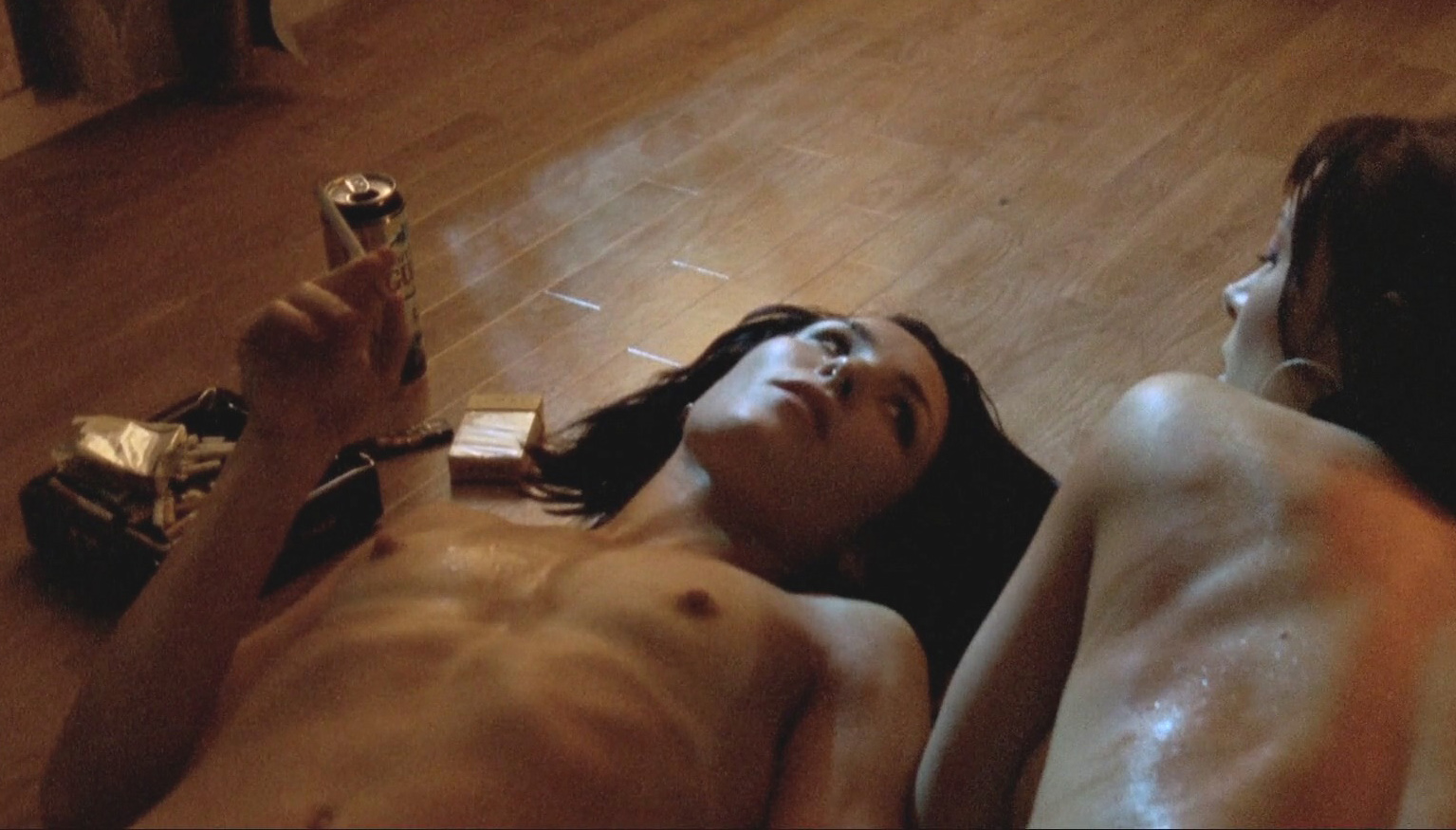 Noomi Rapace topless with her sexy boobs nude smoking on the floor.