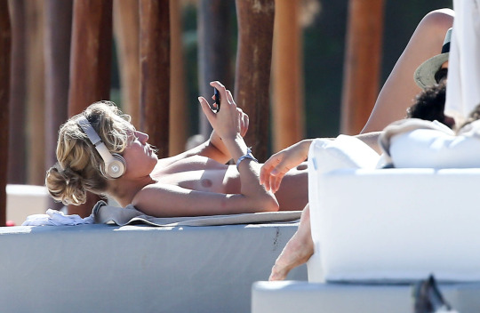 Toni Garrn tanning nude topless outdoors